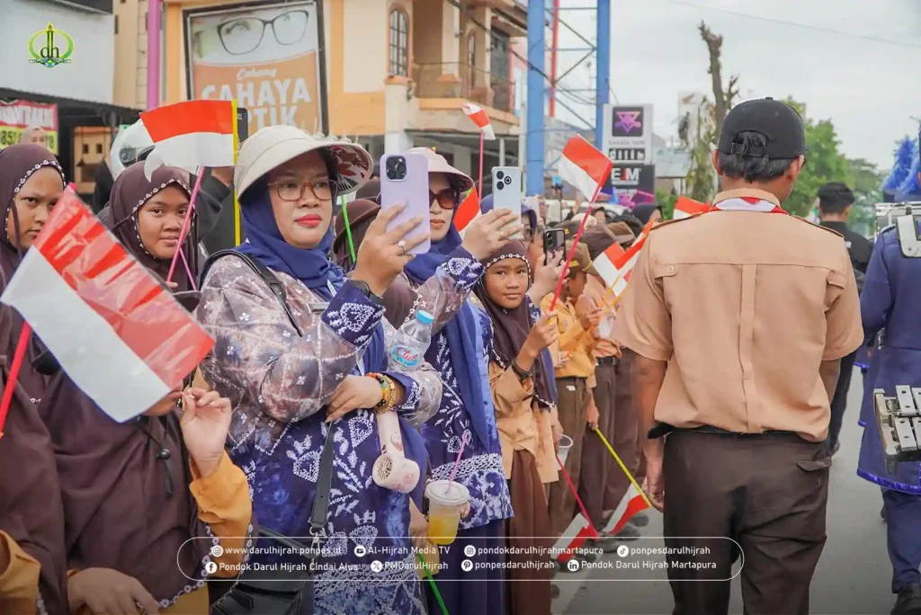 para ibu-ibu mendokumentasikan marching band gema harmony Darul Hijrah milik pesantren darul hijrah yang bersinar di acara MTQ Kalsel 2025